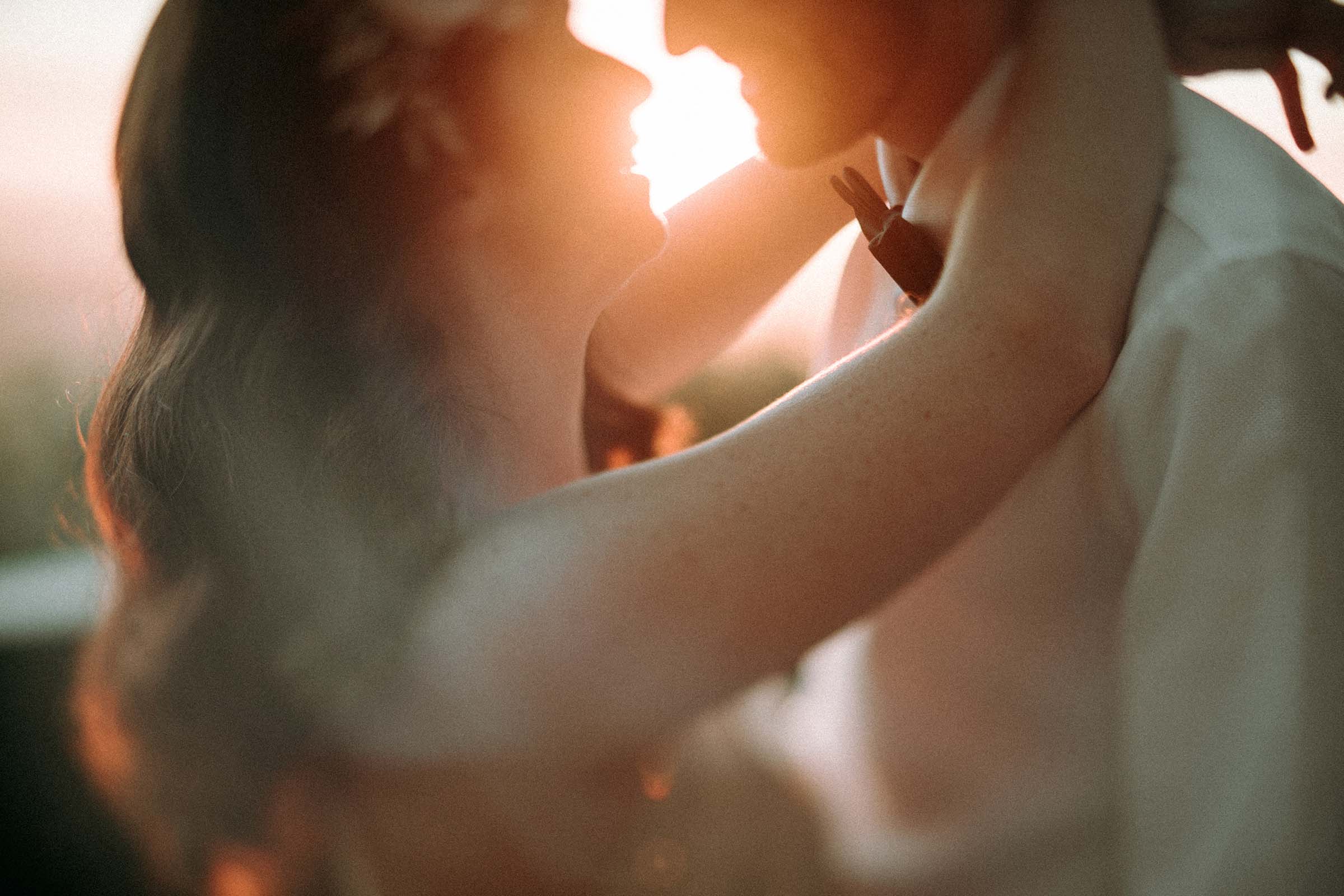 shallow depth of field photo close up couple smiling sunset