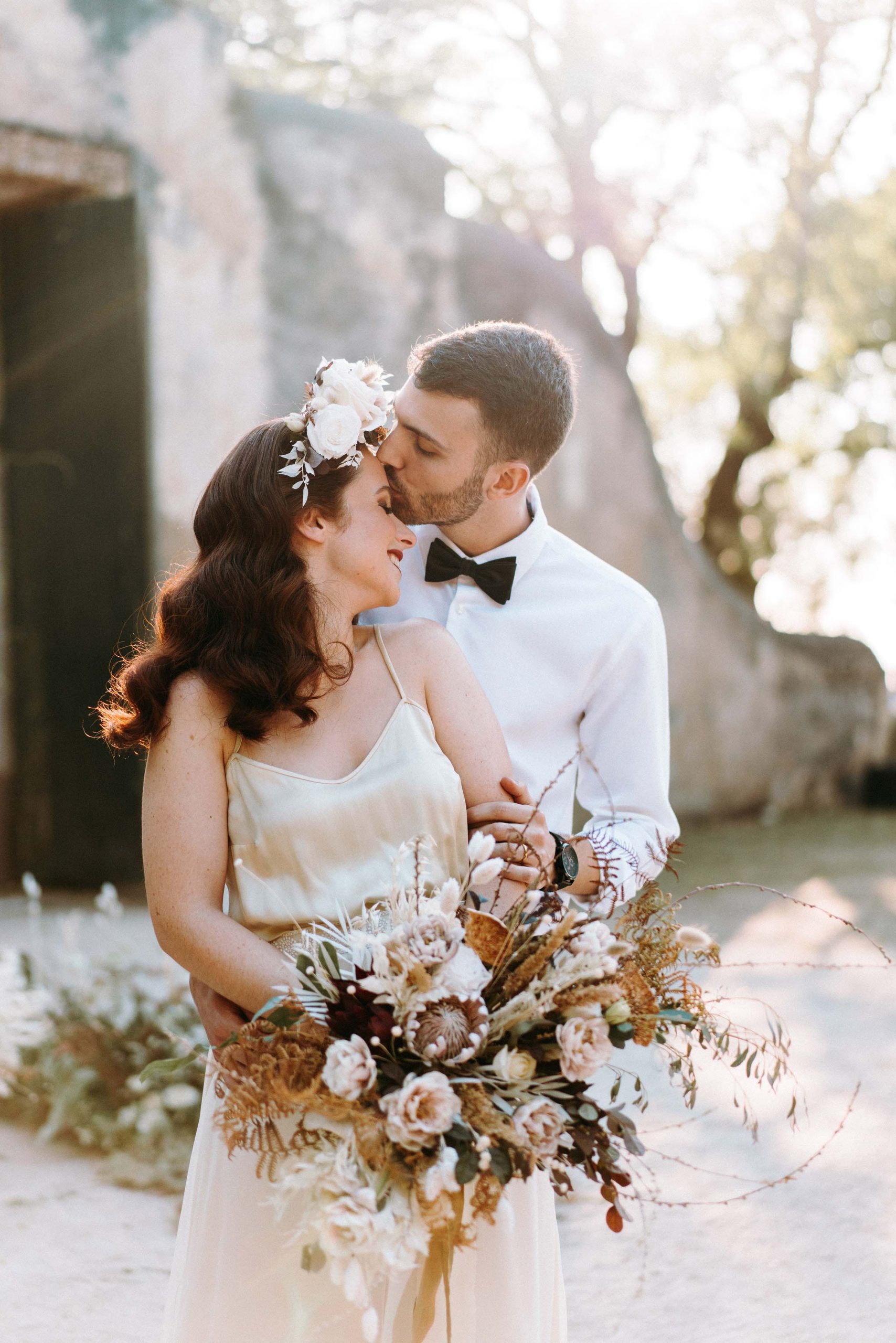 groom kissing brides forehead