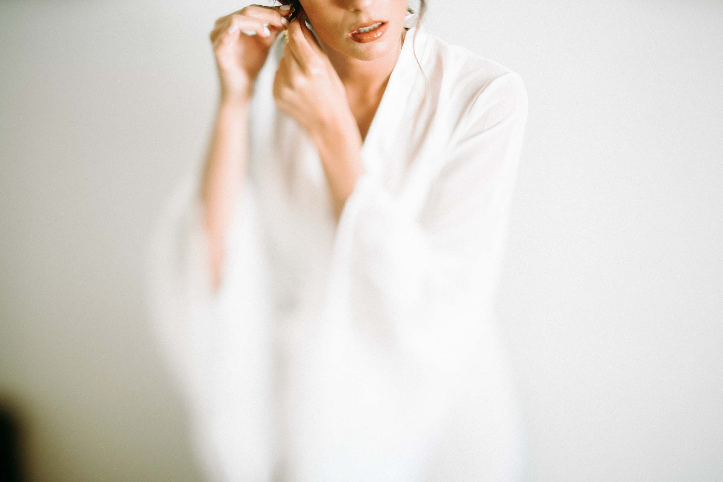 freelens photo of a bride putting ear rings on