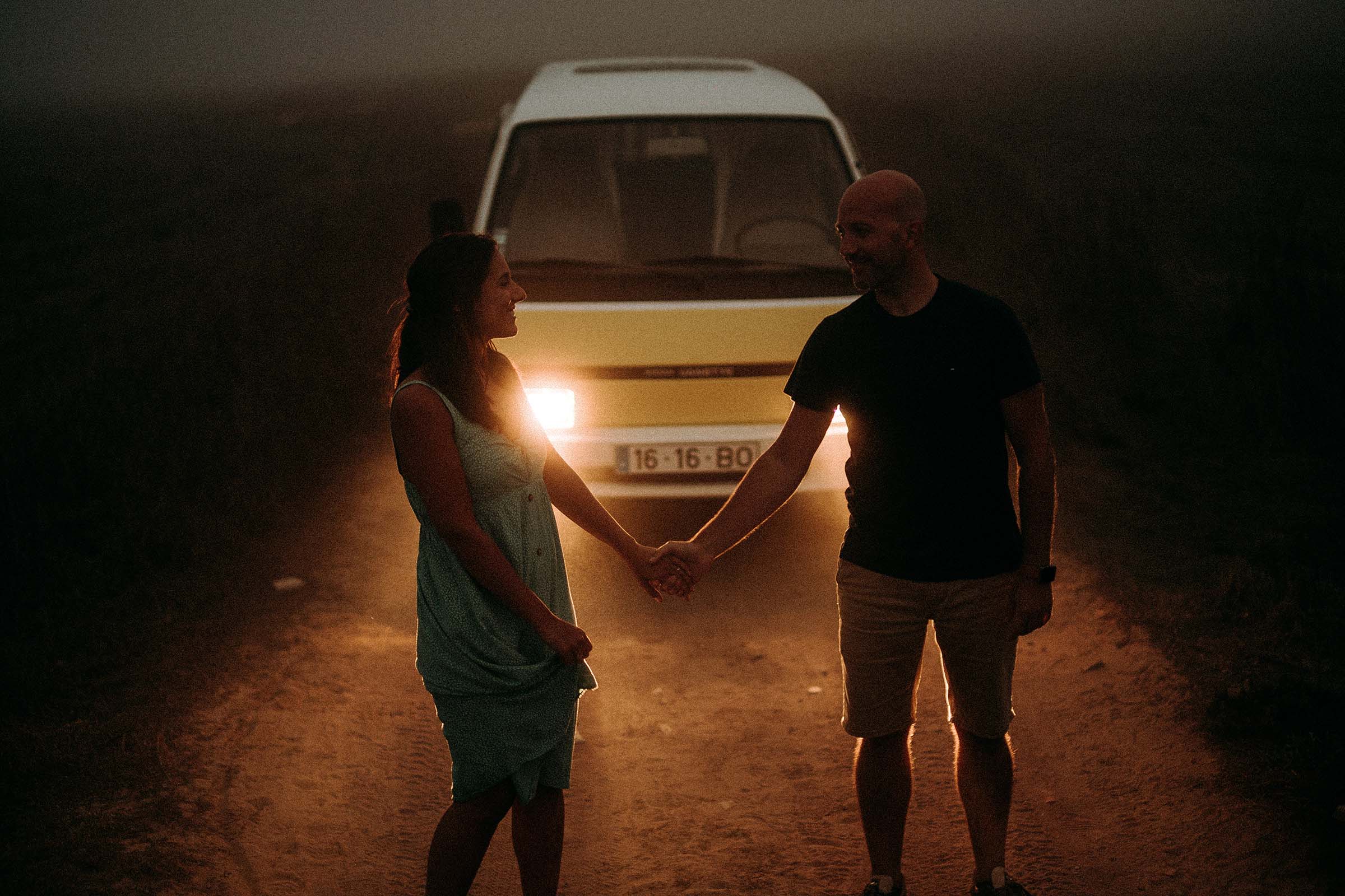 couple holding hands in front of van